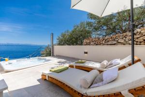 a patio with two beds and a hot tub at Seafront Holiday Home - Private Jacuzzi in Blato
