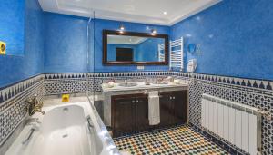 ein blaues Badezimmer mit Badewanne und Waschbecken in der Unterkunft Riad Fes Maya suite & spa in Fès + 33 Fotos