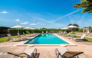 a swimming pool with chairs and umbrellas at Son Capellot Dos in Felanitx