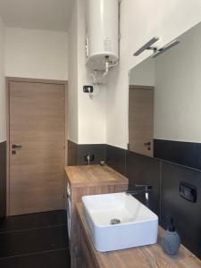 a bathroom with a white sink and a mirror at Appartamento con vista su Brunate in Olgiate Comasco