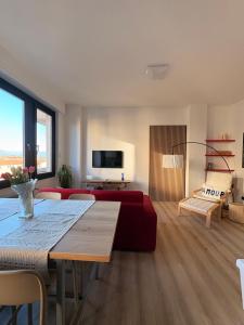 a living room with a table and a red couch at Appartamento con vista su Brunate in Olgiate Comasco