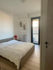 a white bedroom with a bed and a window at Appartamento con vista su Brunate in Olgiate Comasco
