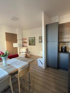 a kitchen and living room with a table and a refrigerator at Appartamento con vista su Brunate in Olgiate Comasco