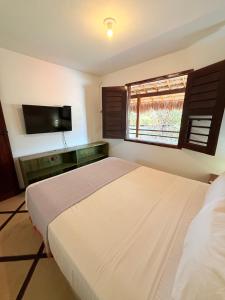 a bedroom with a large bed and a window at Rede Andrade Calamarina in Jericoacoara
