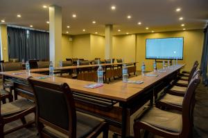 ein großer Konferenzraum mit einem langen Tisch und einem Bildschirm in der Unterkunft Greenside Hotel in Arusha + 128 Fotos