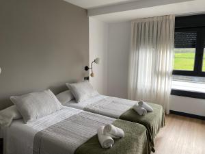 two beds in a bedroom with two towels on them at Pensión Casa Cancela in Palas de Rei