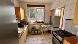 a small kitchen with a table and a refrigerator at Noclegi Witoszyn - Akacjowa 2 in Witoszyn Dolny