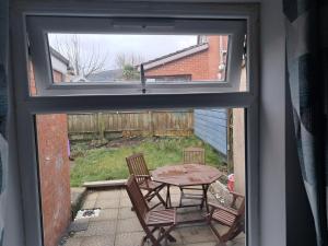 a window view of a patio with a table and chairs at Entire House in Belfast