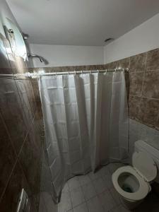 a bathroom with a shower curtain and a toilet at Pepina Mina Clavero in Mina Clavero