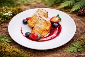 a plate of food with fruit on a table at Malutkie Resort in Radomsko