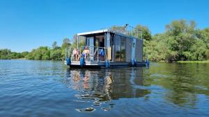 a house boat on the water on a river at Hausboot Havelrobbe in Brandenburg an der Havel
