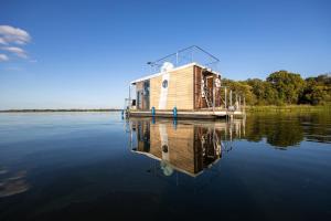 a house boat on the water on a lake at Hausboot Havelrobbe in Brandenburg an der Havel
