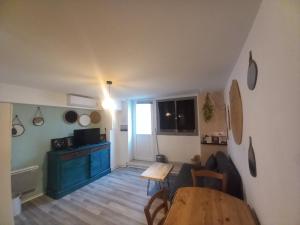 a living room with a table and a kitchen at Le cosy in Clermont-lʼHérault +10 photos