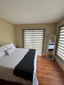 a bedroom with a bed and a chair in it at Cabañas Varas in Osorno