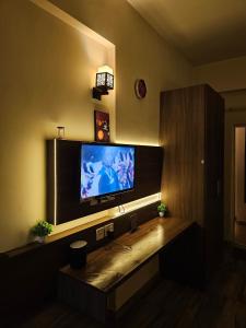 a living room with a flat screen tv on a wall at The Urban Perch in Greater Noida