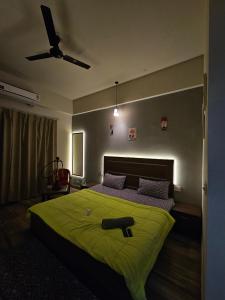 a bedroom with a large green bed with a ceiling fan at The Urban Perch in Greater Noida