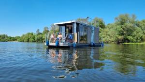 a house boat on the water on a lake at Hausboot Havelrobbe in Brandenburg an der Havel +20 photos