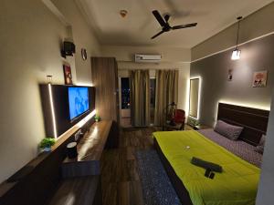 a bedroom with a green bed and a flat screen tv at The Urban Perch in Greater Noida