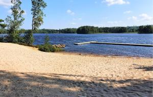 a beach with a dock in the middle of a lake at Stunning Home In Örkelljunga With Sauna in Orkelljunga