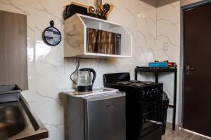 a small kitchen with a stove and a microwave at Little Haven! in Rustenburg