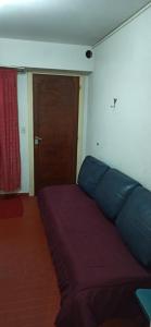 a bedroom with a bed with blue sheets and a door at San Berardo Brava 3 sobre costanera in San Bernardo