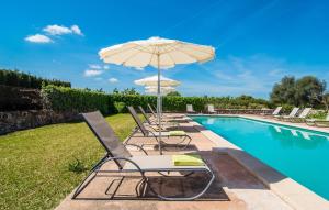 a group of chairs and an umbrella next to a swimming pool at Son Capellot Tres in Felanitx +43 photos