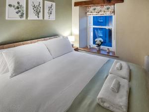 a bedroom with a large white bed with a window at 13 Doomgate Cottage - Uk45056 in Appleby