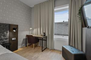 a hotel room with a desk and a window at Home Hotel Astoria in Hamar +20 photos