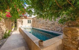 a swimming pool in front of a stone wall at Casa Max in Artá