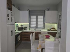a kitchen with white cabinets and a table with chairs at A&A Apartment in Piraeus