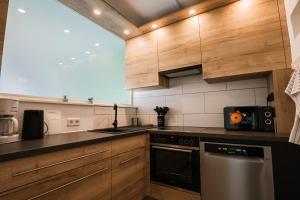 a kitchen with wooden cabinets and a stove top oven at Hannas Lieblingsplatz in Marburg an der Lahn