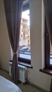 a bedroom with a window with a view of a building at Studio Kalina Green Life in Pamporovo +2 photos