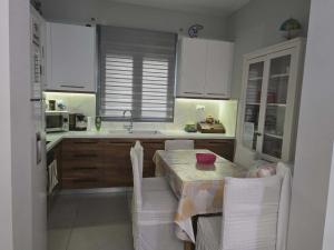 a kitchen with a table and chairs and a kitchen with white cabinets at A&A Apartment in Piraeus +10 photos