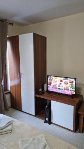 a room with a tv on a desk in a room at Studio Kalina Green Life in Pamporovo