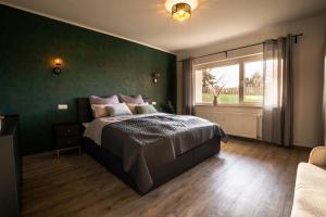 a bedroom with a bed with green walls and a window at Hannas Lieblingsplatz in Marburg an der Lahn +18 photos