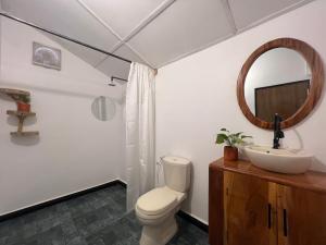 a bathroom with a toilet and a sink and a mirror at C U Hostel in Trincomalee