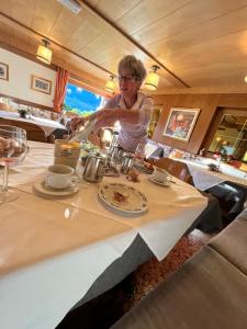 a woman sitting at a table in a restaurant at Hotel Panorama in Cavalese