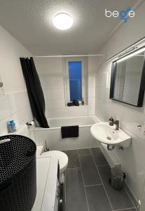 a bathroom with a sink and a toilet and a tub at BEGE APARTMENTS Next Level Sleep in Niederdorla +46 photos