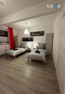 two beds in a large room with wooden floors at BEGE APARTMENTS Next Level Sleep in Niederdorla