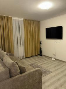a living room with a couch and a flat screen tv at La Sibip in Târgu Neamț