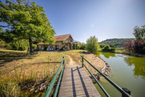 a bridge over a river in front of a house at Zenitude Villa - Indoor Pool & Jacuzzi in Jezainville