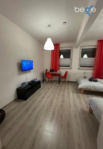 a living room with a bed and a desk with a television at BEGE APARTMENTS Next Level Sleep in Niederdorla