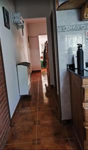 a hallway leading into a kitchen with a tile floor at Arcoiris in General Acha +1 photo