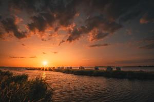 a sunset over a body of water with the sun setting at Marina Martinshafen in Sassnitz
