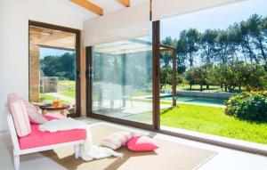 a living room with a pink chair and a large window at Ca Ses Nines in Cala Bona