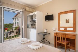 a bedroom with a bed and a desk and a window at Dionysios Studios in Skala