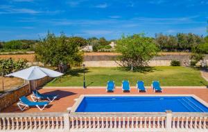 a swimming pool with chairs and an umbrella at Sa Vileta in Sencelles