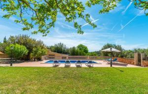 a swimming pool with benches and an umbrella at Sa Vileta in Sencelles