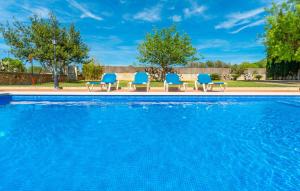 a group of blue chairs sitting next to a swimming pool at Sa Vileta in Sencelles