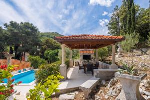 a patio with a pergola next to a pool at Villa Nada - Unique & Artistic in Korčula